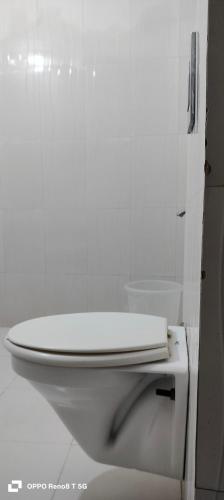 a bathroom with a white toilet in a white room at The Grand Paramont Near Delhi Airport Free Airport Drop in New Delhi