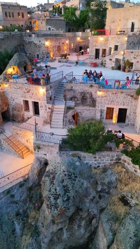 a group of people sitting on the stairs of a building at Kapadokya Ihlara Konakları Otel Konak Odaları in Guzelyurt
