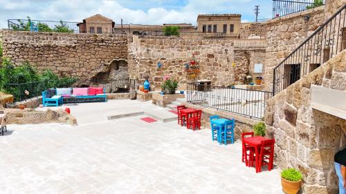 a patio with red and blue tables and chairs at Kapadokya Ihlara Konakları Otel Konak Odaları in Guzelyurt