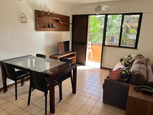 un soggiorno con un tavolo e un divano di Genipabu Summer House Guarajuba a Camassari