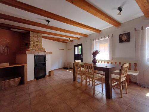 a kitchen and dining room with a table and a fireplace at Domek v Arnoštově u Pecky 