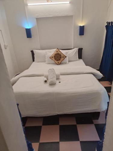 a bedroom with two beds and a checkered floor at Dylan Cafe And Guest House in Jodhpur