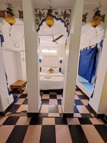 a room with a white bed and a checkered floor at Dylan Cafe And Guest House in Jodhpur