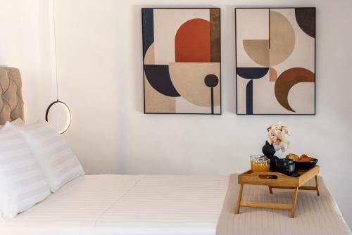 a bedroom with a bed with three paintings on the wall at Tinian Sunset Suite in Istérnia