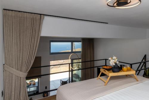 a bedroom with a bed and a large window at Tinian Sunset Suite in Istérnia