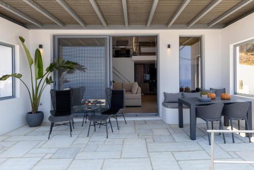 a living room with a patio with a table and chairs at Tinian Sunset Suite in Istérnia