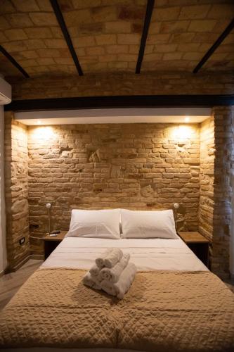 a bedroom with a white bed with a brick wall at AL 54 Accommodation in San Benedetto del Tronto