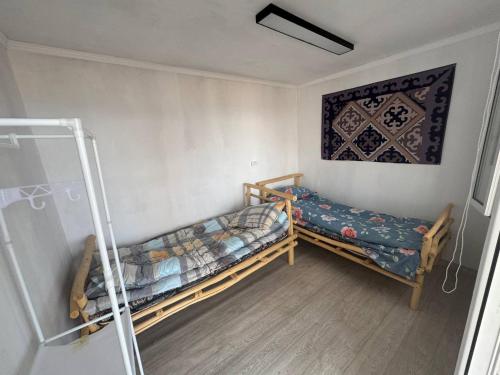 a room with two beds and a painting on the wall at Crocodile Tash in Tong