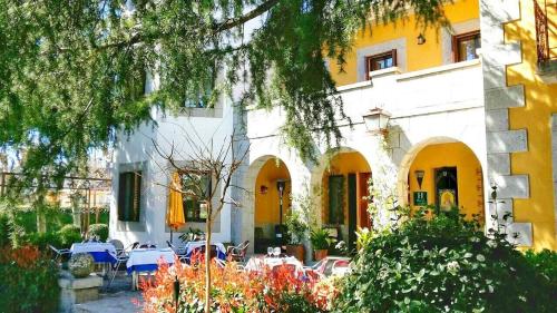 a building with tables and chairs in front of it at Hotel Punta me Torreblanca Palace in Guadarrama