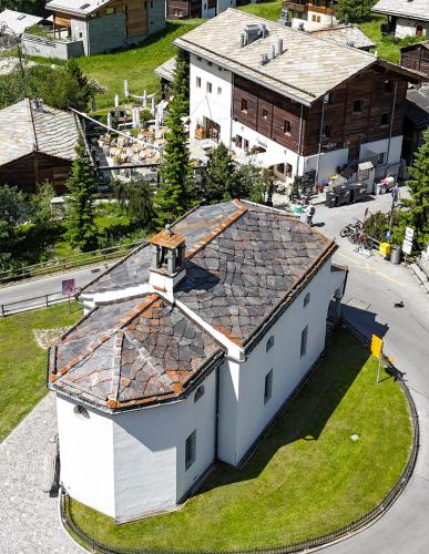 an overhead view of a white house with a roof at Sonnmatten Boutique Hotel & Apartments Zermatt in Zermatt