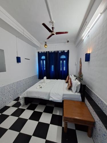 a bedroom with a bed and a checkered floor at Dylan Cafe And Guest House in Jodhpur