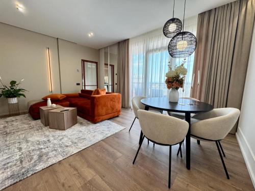 un soggiorno con tavolo, sedie e divano di M&M Urban Escape a Arad