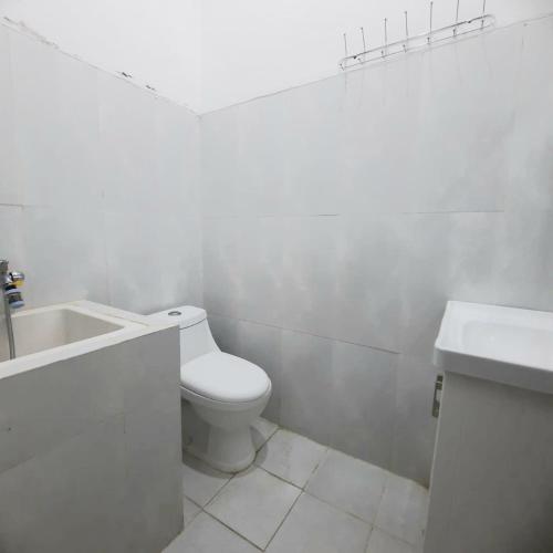 ein weißes Badezimmer mit Toilette und Waschbecken in der Unterkunft MUTI Homestay Syariah in Sumberwaras