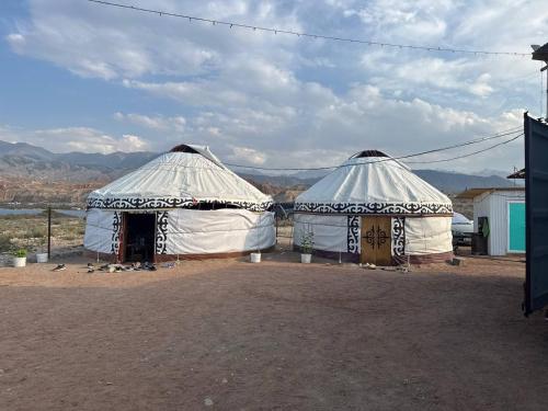 two large white tents with mountains in the background at Crocodile Tash in Tong