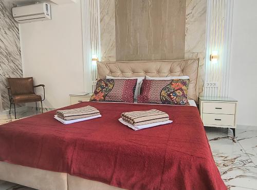 a bedroom with a red bed with towels on it at Villa vista mare in Zagrađe