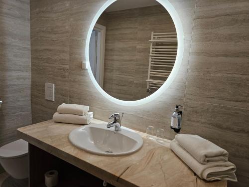 a bathroom with a sink and a mirror at Hotel Verde in Koszalin