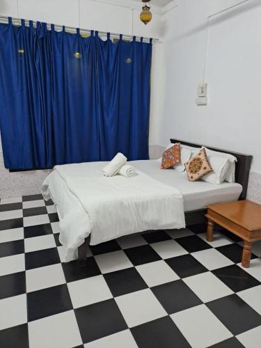 a bedroom with a bed and a blue curtain at Dylan Cafe And Guest House in Jodhpur