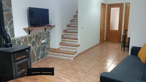 a living room with a staircase with a tv at Casa MªÁngeles in Puebla de Arenoso