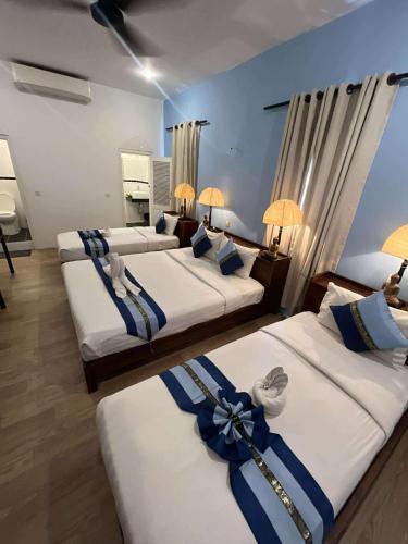 a group of three beds in a room at Pride Villa Cambodia in Phnom Penh