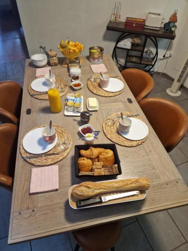a wooden table with breakfast food on it at Chambre double l'escapade colorée in Rieux-Minervois