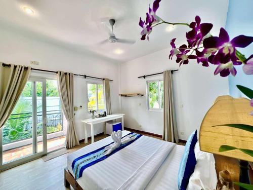a bedroom with a bed with purple flowers on the wall at Pride Villa Cambodia in Phnom Penh