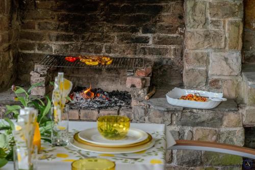 a table with plates of food and a fireplace at La Pastorale in Manhay