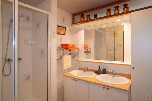 a bathroom with two sinks and a shower at La Pastorale in Manhay