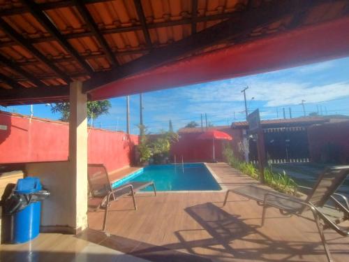 een terras met stoelen en een zwembad bij Sinuca, churrasqueira e fogueira a 300 metros do mar in Itanhaém