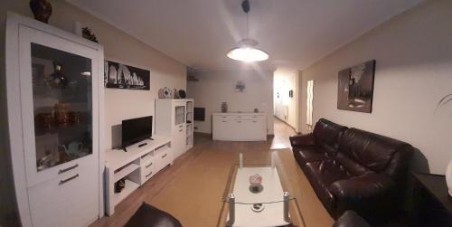 a living room with a couch and a tv at Apartamentos Maliayo B in Villaviciosa