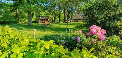 a garden with a park with a bench and flowers at Bed & Breakfast Twekkelo in Enschede