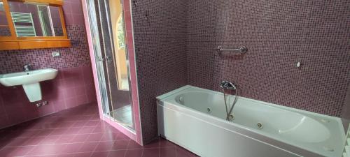 a bathroom with a tub and a sink and pink tiles at Bed and Bike in Vasto