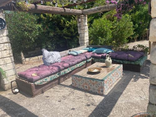 two couches sitting under a pergola at Chambre au Mas des Fontaines in Jonquières-et-Saint-Vincent