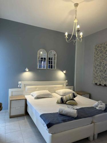 a bedroom with a large white bed with a chandelier at IVAS Pelion in Agios Ioannis Pelio
