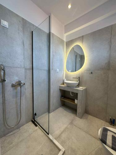a bathroom with a shower and a sink and a mirror at IVAS Pelion in Agios Ioannis Pelio