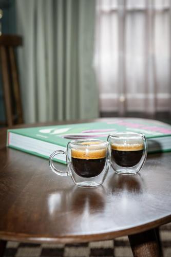 two cups of coffee sitting on a wooden table at Maison Rokxy - Luxury Apartments in London