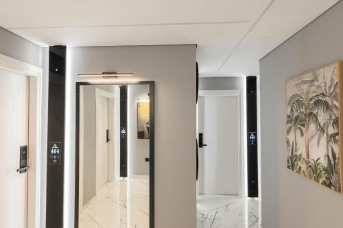 a hallway with white walls and a painting on the wall at Hotel Elite Sarande in Sarandë