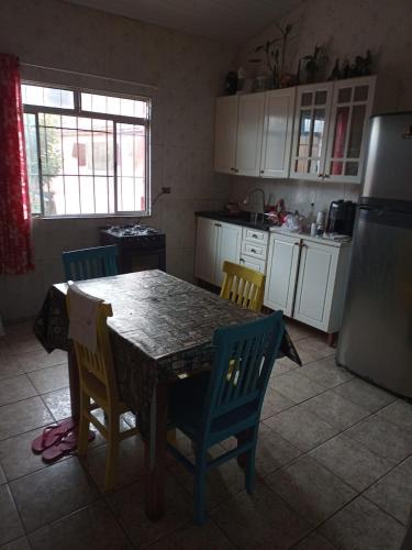 a kitchen with a table and chairs and a refrigerator at Casa da Diversidade para todos in Peruíbe