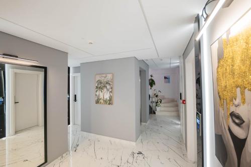 a hallway with white walls and marble floors at Hotel Elite Sarande in Sarandë