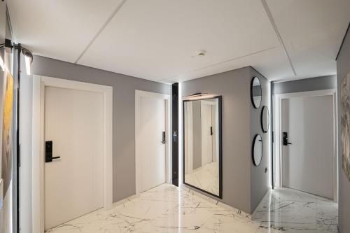 a hallway with two white doors and a mirror at Hotel Elite Sarande in Sarandë