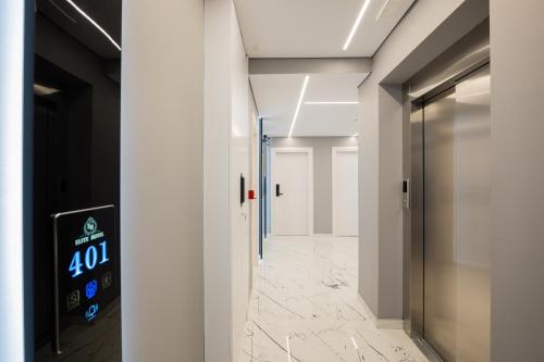 a hallway with white walls and a glass door at Hotel Elite Sarande in Sarandë