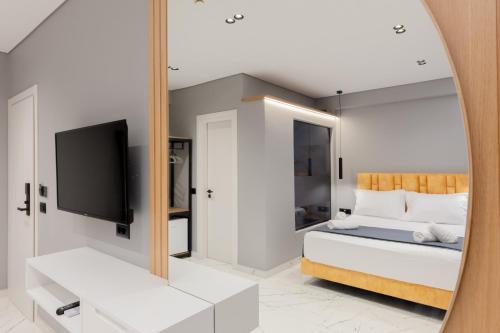 a bedroom with a bed with a mirror and a tv at Hotel Elite Sarande in Sarandë