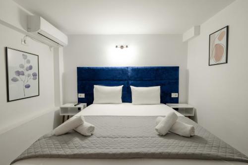 a bedroom with a large bed with a blue headboard at Hotel Elite Sarande in Sarandë