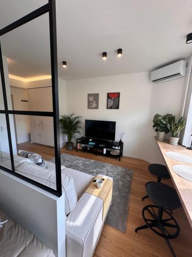 a living room with a white couch and a large mirror at Algirdo Sunlight Studio in Vilnius