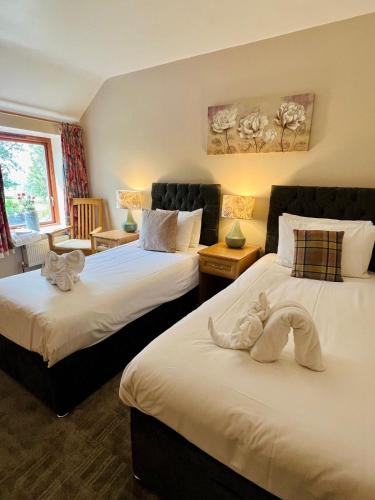 two beds with stuffed animals on them in a room at Cottage Lea's Country Hotel & Restaurant in Pickering