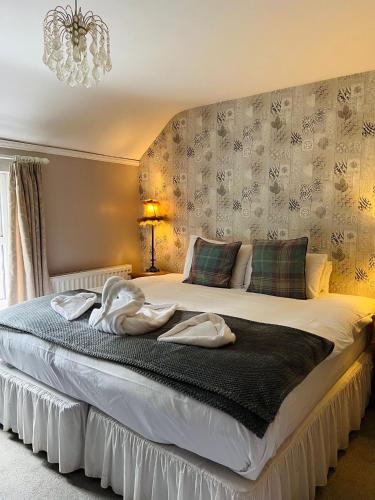 a bedroom with a large bed with towels on it at Cottage Lea's Country Hotel & Restaurant in Pickering
