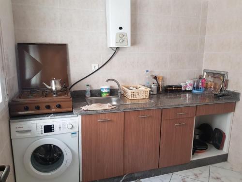 eine Küche mit einem Herd und einer Waschmaschine in der Unterkunft Appart à Martil in Martil