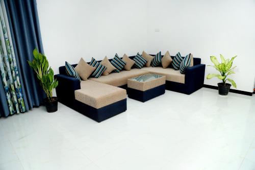 a couch with pillows on it in a room at Sandakini Home Rest in Ahangama