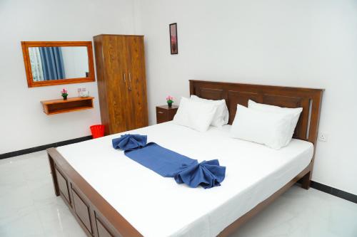 a bedroom with a bed with a blue bow on it at Sandakini Home Rest in Ahangama