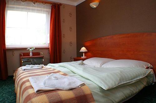 
A bed or beds in a room at Hotel Zbyszko
