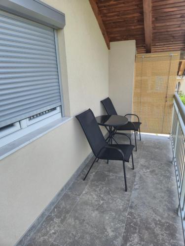 two chairs and a table on a balcony at Apartments Halilovic in Hadžići